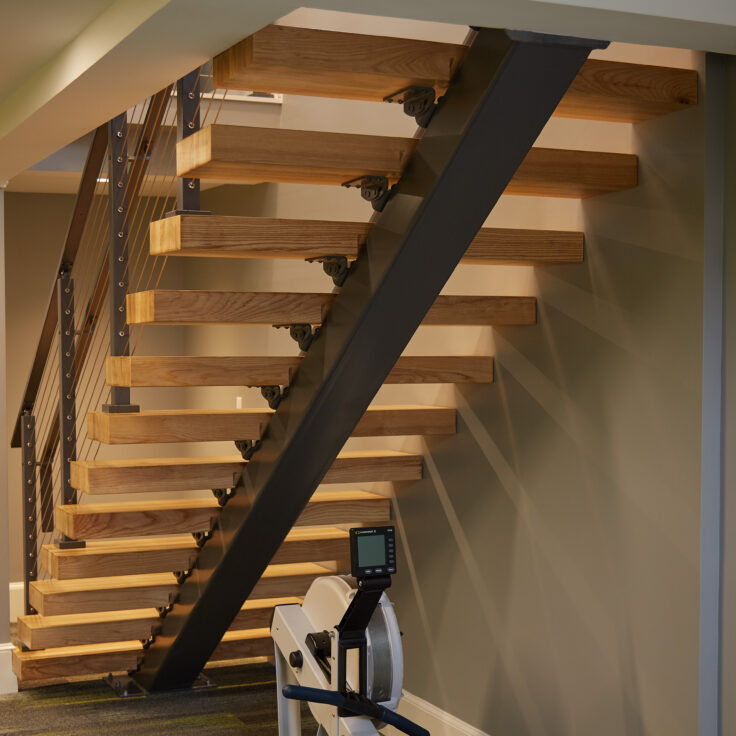 Floating Stair Stringer with Black Powder Coat and Red Oak Treads Seen From Behind