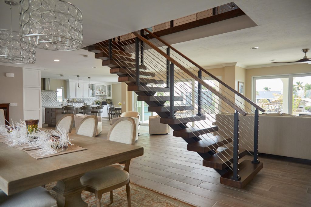 straight stairs in an open concept home feature white oak treads and rod railing.