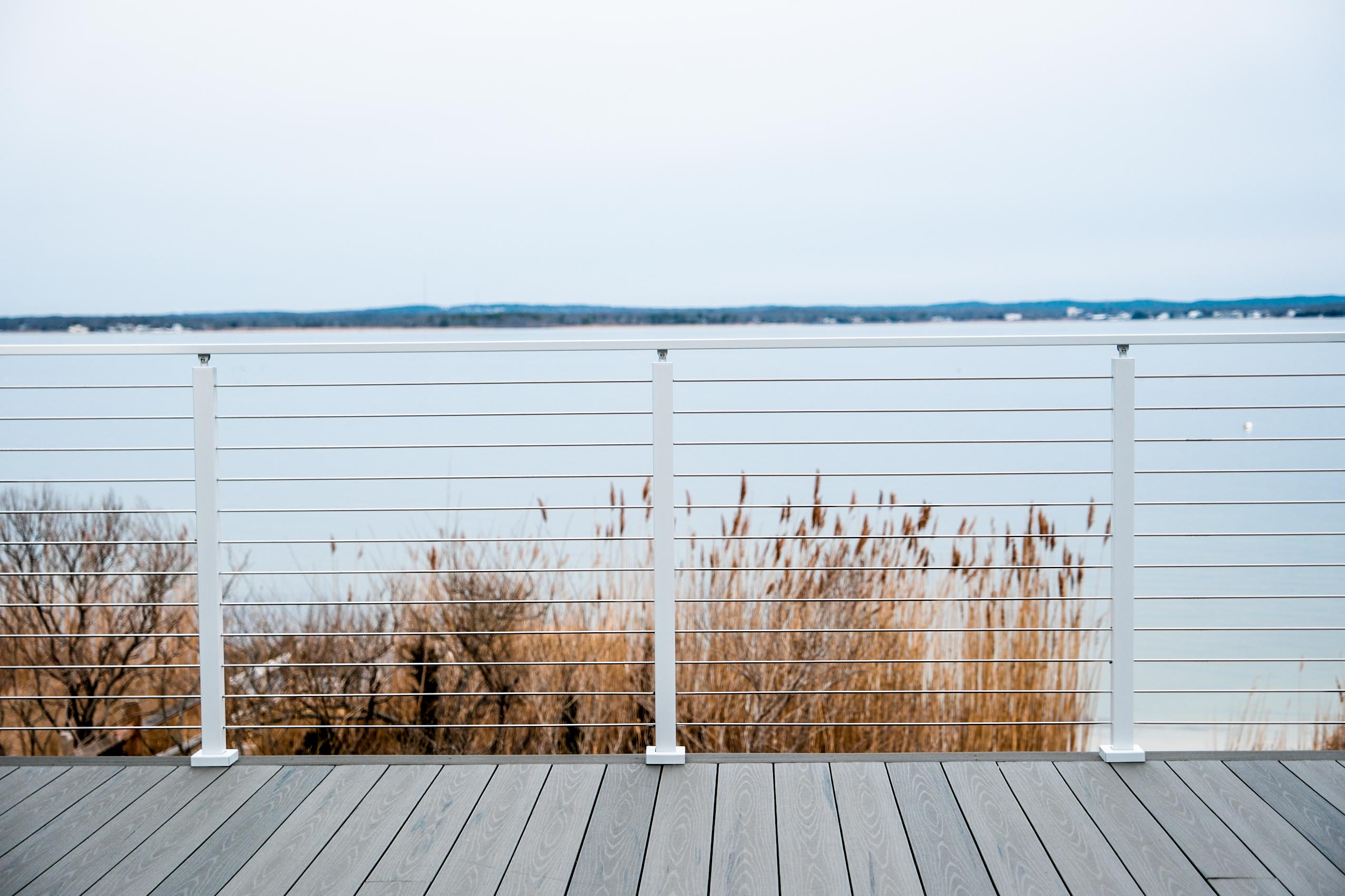 White powder-coated cable railing system on a cold, coastal deck