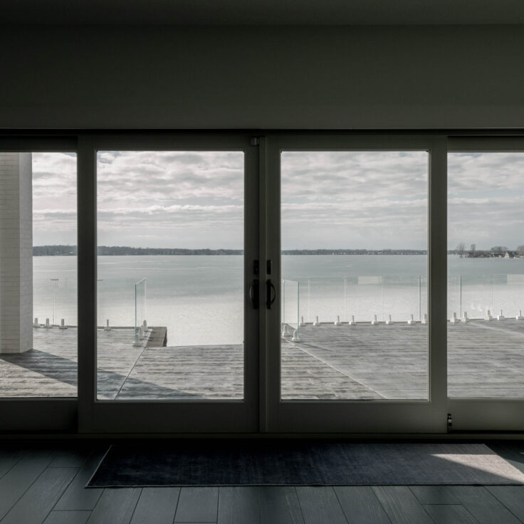 A large glass door looking out to lots of Glass Railing being held up by White Talons